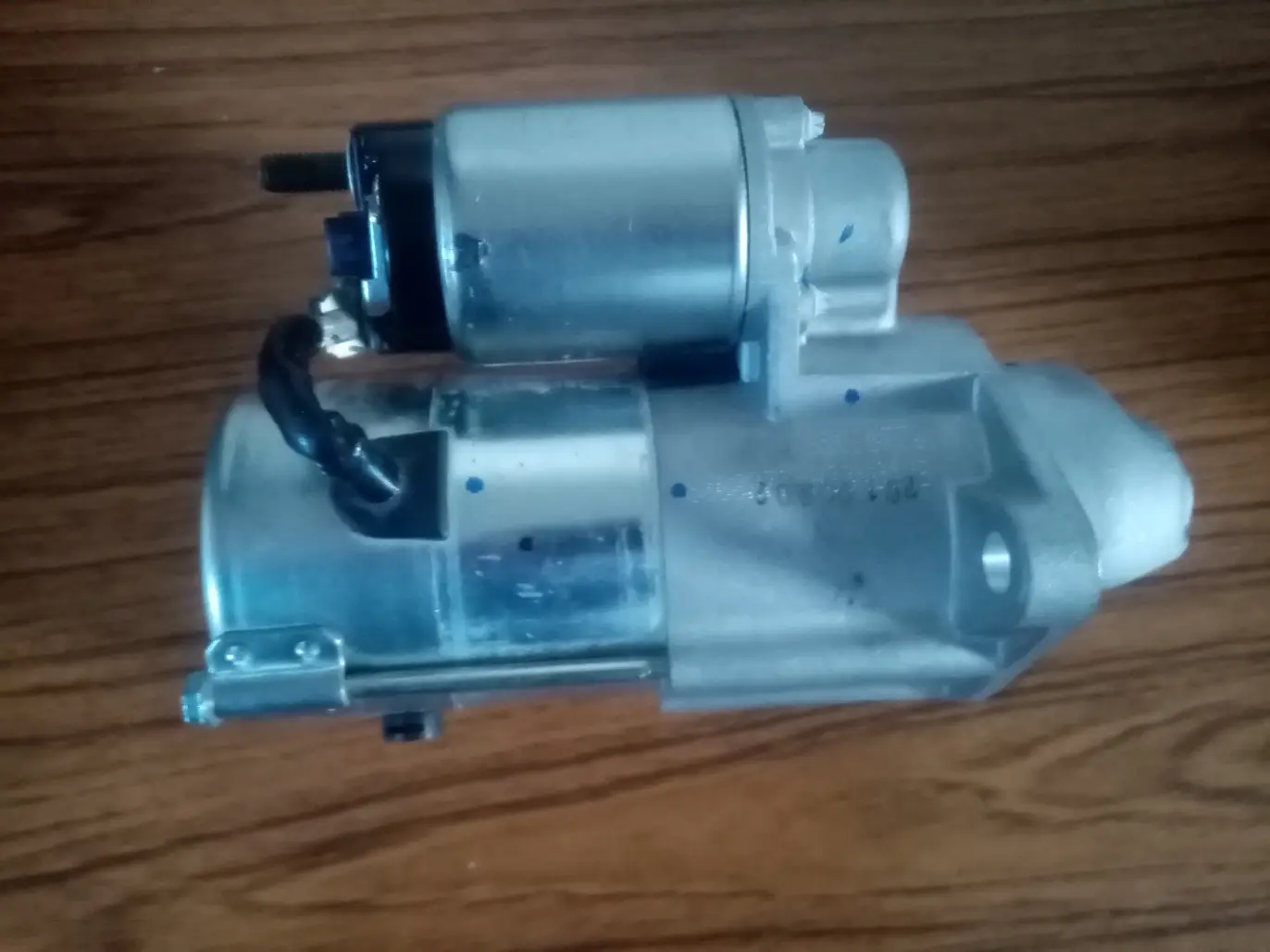 Brand new car starter motor on workbench showing replacement parts for fixing common car starter problems - professional electromechanic repair