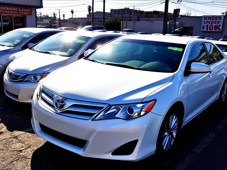 Line of used Toyota Camry sedans for sale under $10,000 at a local dealership.

