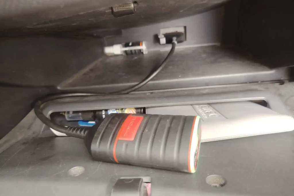 A mechanic plugs an OBD2 scanner into a car’s diagnostic port to troubleshoot why the OBD2 is not connecting.